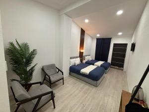 a hotel room with a bed and a chair at Borunda Suites in General Trías