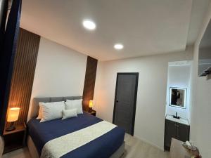 a bedroom with a bed and a television in it at Borunda Suites in General Trías