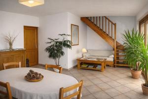 a living room with a table and a staircase at De Cian in Saint-Valéry-sur-Somme