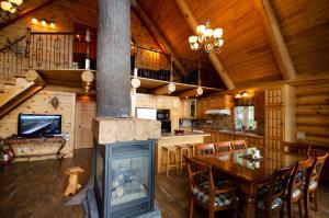 a kitchen and dining room with a fireplace in a log cabin at Le Chalet Bois Rond Relax in Saint-Tite-des-Caps