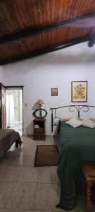 a bedroom with a green bed and a wooden ceiling at Puerto Colla in Esquina