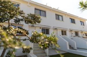 a white building with stairs in front of it at Kymo Fig Tree Bay House in Protaras