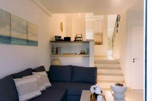 a living room with a blue couch and stairs at Kymo Fig Tree Bay House in Protaras