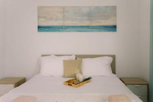 a bedroom with a bed with a painting on the wall at Kymo Fig Tree Bay House in Protaras