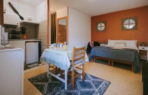 a room with a table and a bed and a kitchen at Hôtel Studios Les Acacias in Saint-Paul-lès-Dax