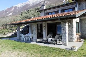 a house with a patio with chairs and a table at Villa Manuela-Lake View in Brenzone sul Garda