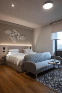 a bedroom with a bed and a blue couch at Mimi Hotel Chisinau Jolly Alon in Chişinău