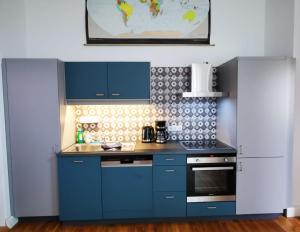a kitchen with blue cabinets and a stove top oven at ehemalige Kirche in neuem Glanz in Oranienbaum-Wörlitz