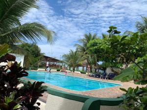 a swimming pool in a resort with palm trees at Hotel La Tolita in Atacames