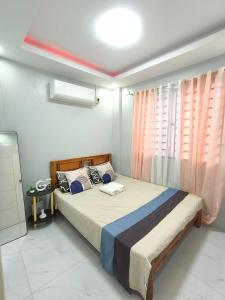 a bedroom with a large bed with pink curtains at Casipe Transient House in Tanay +19 photos