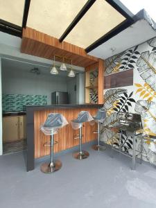 a kitchen with three bar stools in front of a counter at Casipe Transient House in Tanay