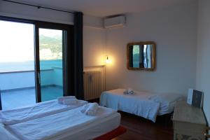 a hotel room with two beds and a mirror at Villa Manuela-Lake View in Brenzone sul Garda