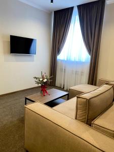 a living room with couches and a tv and a window at Grand Christer Hotel in Kyiv