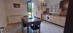 a kitchen with a table and a washing machine at Charme rustico con ampio giardino e piscina con due camere in Carrara