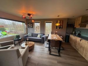 a living room with a couch and a table at Buitenverwachting in Heelweg