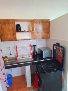 a kitchen with a stove and a counter top at Adventure studio apartment in Mtwapa +4 photos