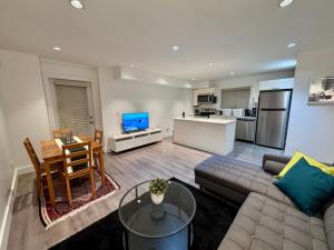 a living room with a couch and a table and a kitchen at A&A Resident - Modern North Vancouver 2BR Suite in North Vancouver