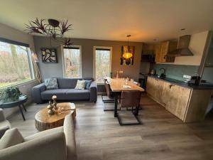 a living room with a couch and a table at Buitenverwachting in Heelweg +26 photos