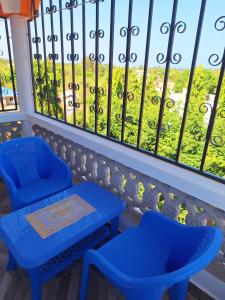 two blue chairs and a table in front of a window at Adventure studio apartment in Mtwapa