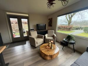 a living room with a wooden coffee table and chairs at Buitenverwachting in Heelweg