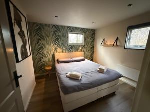 a bedroom with a bed with two towels on it at Buitenverwachting in Heelweg