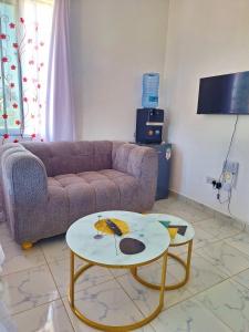 a living room with a couch and a table at Adventure studio apartment in Mtwapa