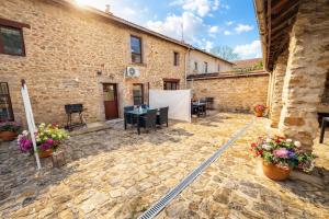 a courtyard in a stone building with tables and flowers at Gites Le Chezeau in Saint-Amand-Magnazeix