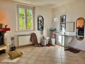 a living room with a fireplace and a window at Dimora dei Passi Lenti in Montegranaro
