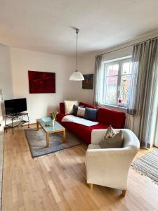 a living room with a red couch and a table at Ferienwohnung zum Utzen in Berching