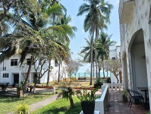 a view from the courtyard of a building with palm trees at Haad Piti Resort in Ban Plai Thon