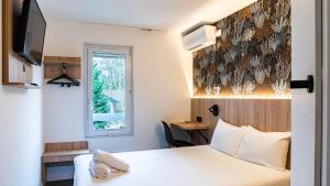 a hotel room with a bed and a window at Kyriad ECO - Anglet Côte Basque in Anglet