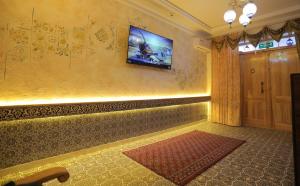 a room with a television on a wall with a rug at Oasis al Khiva Boutique Hotel Inside Citadel in Khiva