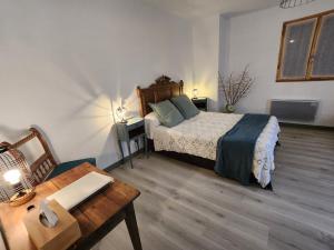 a bedroom with a bed and a table and a table sidx sidx sidx at La Bouillarde in Suze
