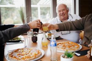 a group of people sitting around a table with pizza at Camping ArdenParks La Petite Suisse - Maeva Vacansoleil in Manhay