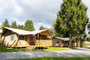 a large building with a tent on the side of a road at Camping ArdenParks La Petite Suisse - Maeva Vacansoleil in Manhay