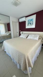 a bedroom with a large white bed with a mirror at Punta del Este, Sol y Luna II, Departamento 301 in Punta del Este +42 photos