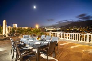 a dining table on a balcony with a view of the city at Villas Guzman - Grandiosa in Calpe