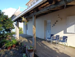 a porch of a house with chairs and a table at Casa da Volta - Porto Moniz in Porto Moniz