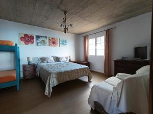 a bedroom with two beds and a flat screen tv at Casa da Volta - Porto Moniz in Porto Moniz +13 photos