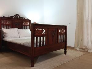 a wooden bed with white pillows in a room at Casa da Volta - Porto Moniz in Porto Moniz