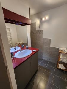 a bathroom with two sinks and a red counter at La Bouillarde in Suze