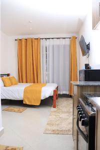 a bedroom with a bed with an orange curtain at Kwetu properties in Nairobi