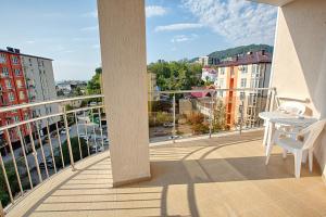 uma varanda com uma mesa e vista para a cidade em Sonata Hotel em Sochi