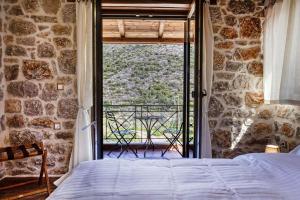a bedroom with a bed and a large window at Elevi Mare Apartment in Tyros +22 photos