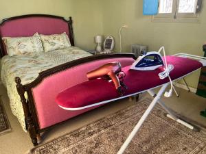 a bedroom with a bed with a pink bed frame with a shoe on it at Le Typique Djerbien in Houmt Souk