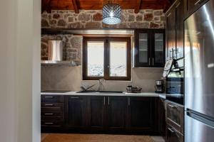 a kitchen with wooden cabinets and a sink and a window at Elevi Mare Apartment in Tyros