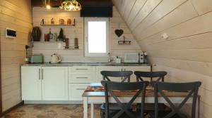 a kitchen with a table and chairs in a tiny house at Aglamp Almaty in Besqaynar