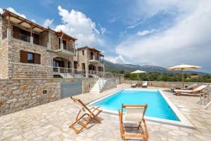 a villa with a swimming pool and a house at Elevi Mare Apartment in Tyros