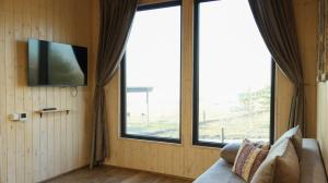 a living room with a couch and a large window at Aglamp Almaty in Besqaynar
