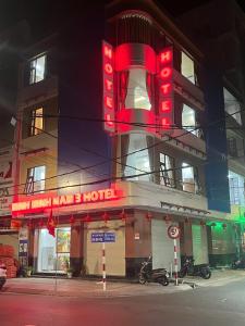 a hotel with a red neon sign in front of it at Minh Minh Nam 3 Hotel in Can Tho